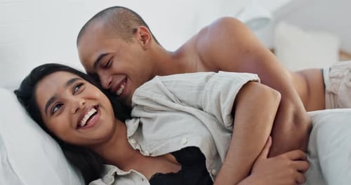 Loving Young Adult Couple Cuddling in Bed