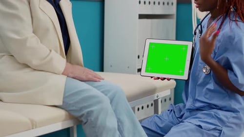 Medical Assistant Holding Digital Tablet with Greenscreen Display