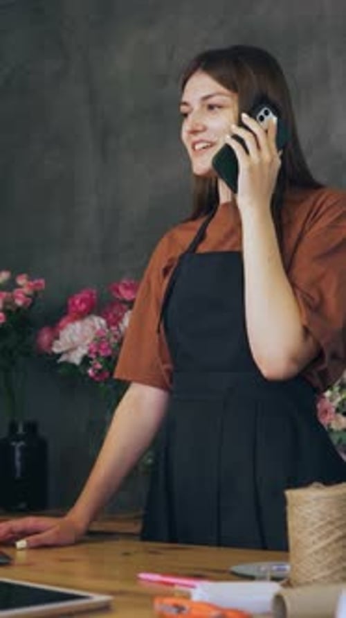 The Seller the Owner of a Flower Shop Talks to the Customer on the Phone and Calculates the Cost of