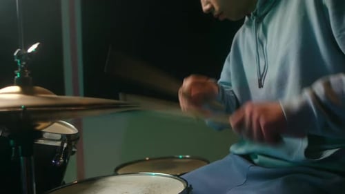 Young Drummer Plays Energetically in Music Studio