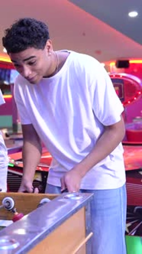 Friends Playing Foosball Table Game in Arcade