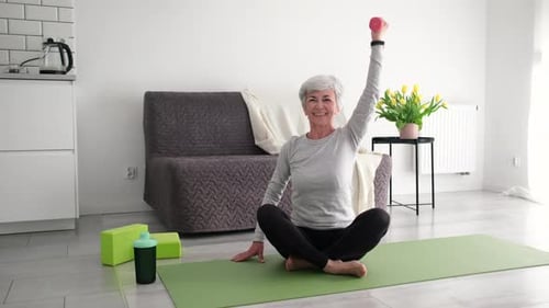 Senior Woman Exercising with Dumbbell at Home