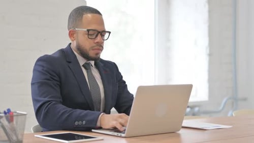 Businessman Working At Laptop and Coughing in Office