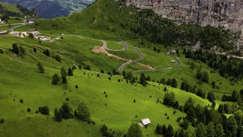 Curvy mountain road in Passo di Giau, Dolomites, Italy, aerial view of alpine switchbacks and green