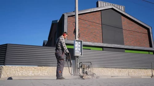 Worker Grinding Concrete with Heavy Equipment