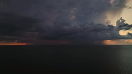 Dark Stormy Clouds Forming on Gloomy Sky During Heavy Rainfall Season Over Sea Surface in Evening
