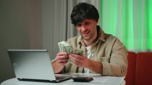 Successful Businessman Counts Money While Sitting in the Living Room