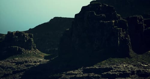 Ancient Rock Formations Cast Long Shadows at Dusk Near Mountains in Nature