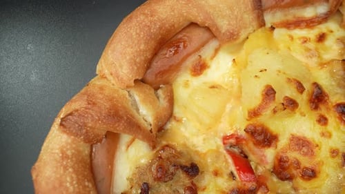 Eine Käsepizza mit Wurst im Makro-Nahaufnahmevideo. 4K.