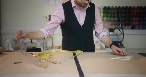 Male Tailor Creating Pattern on Table