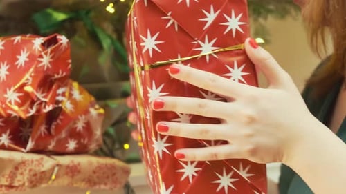 Woman Places Christmas Gift Under Tree