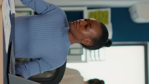 Femme afro-américaine faisant une pause du travail utilisant un ordinateur portable pour boire une gorgée de café ou de thé