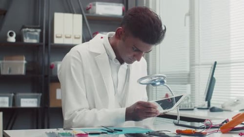 Busy Man Examining Broken Tablet at Service Center