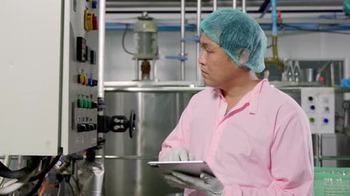 Worker Using Tablet in Beverage Factory Oversees Soda Water Filling