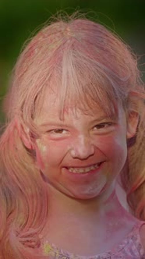 Vertical Video Little Girl in Colorful Paint at Holi Festival Happy and Contented Looking at Camera