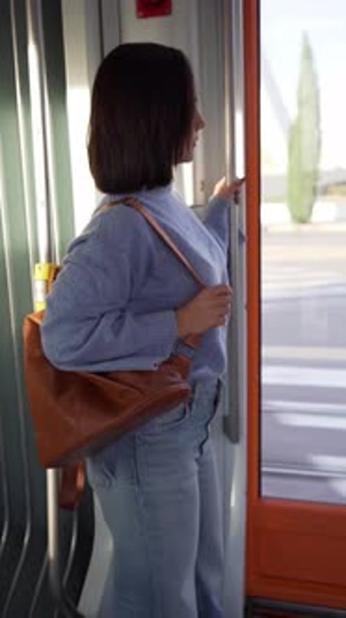 Young Woman Standing near Train Doors Looking Out