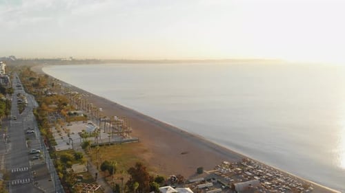 The Camera Flies Along the Sea Beach in the Southern City Near the Mountains