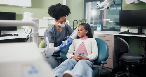 Dentist Explains Procedure to Child Patient in Office