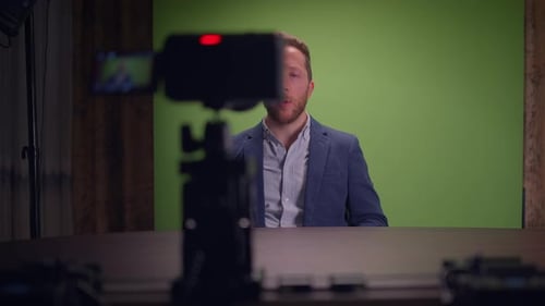 An Engaging Speaker Positioned in Front of a Green Screen Utilizing a Professional Camera