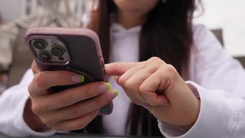Las manos femeninas y el teléfono inteligente de cerca
