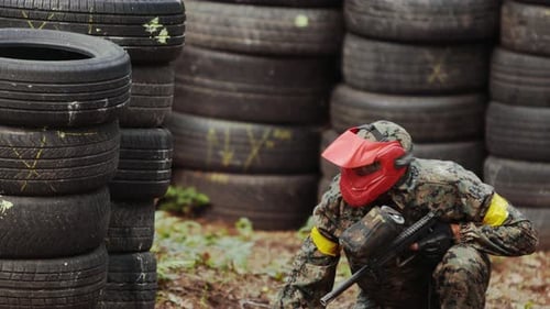 Porträt eines amerikanischen Paintball-Spielers in Maske, der Gegner auf den Krieg zielt