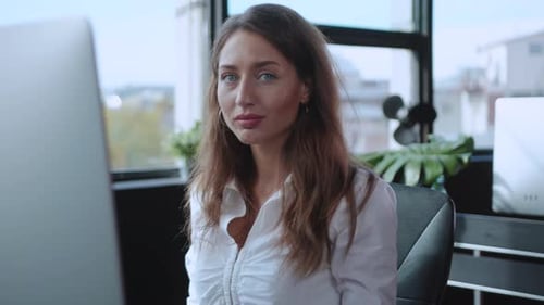 Dedicated and Focused Professional Working on a Computer in a Modern Office Environment