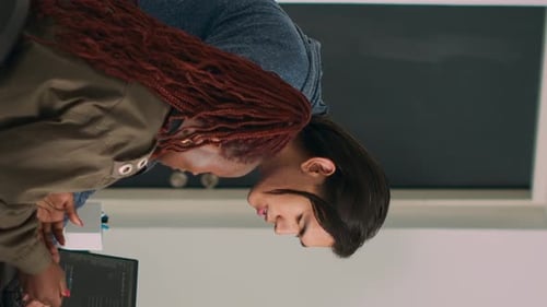 Two Adults Working with Computer Code in Office