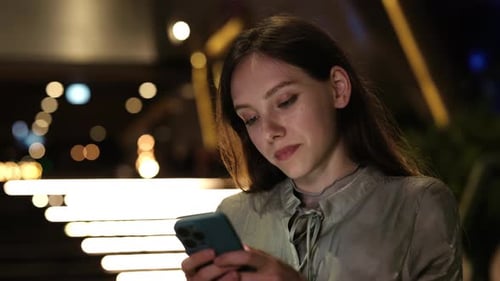 Young Woman Using Smartphone at Night, Close Up