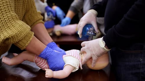 Medical CPR Training on Infant Dummy in Classroom