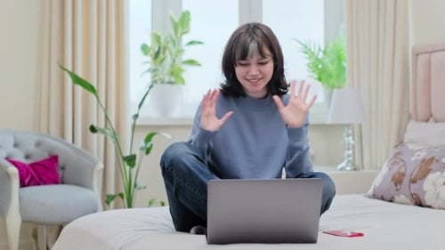 Young Female College Student Having Online Conference Video Call on Laptop at Home