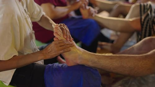 Homem tailandês fazendo massagem nos pés de um homem no mercado de Chiang Mai, foto Câmera lenta