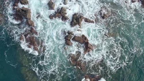 Aerial View of Waves Crashing on Concrete Breakwater Blocks