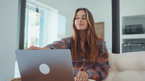 Woman Opening Laptop Computer Indoors in Relaxing Setting