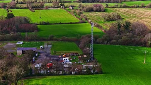 Aerial view of a telecommunication tower in the rural green fields
