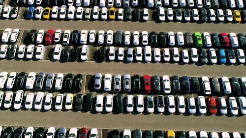 Aerial footage of finished cars ready to be shipped on huge distribution center