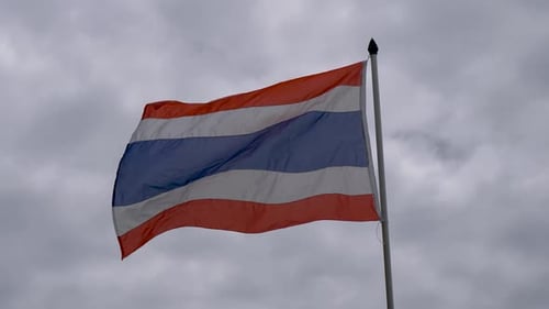 Thai Flag Waving Against Overcast Sky