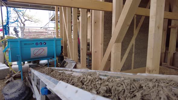 Trabalhador empurrando uma caixa com concreto de cânhamo da correia ...