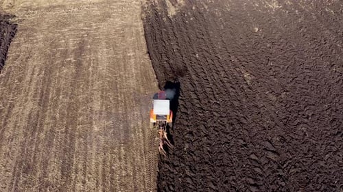Tractor Seeding-Sowing Crops at Agricultural Field. Soil Loosening Aerial Slow Motion