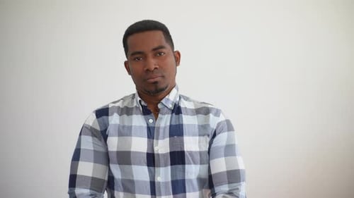 Studio Portrait of Cheerful Cheerful Young African American Man Wearing Plaid Shirt Standing Posing