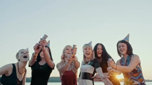 Grupo de amigos felizes celebrando as meninas no lago