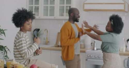 Happy Family Dancing in Kitchen with Singing Child