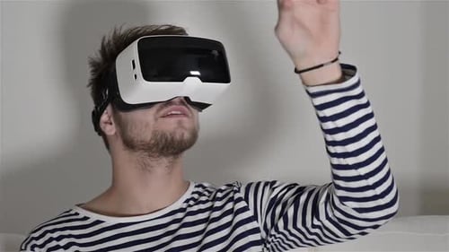 Man Wearing Virtual Reality Goggles. Studio, White Couch