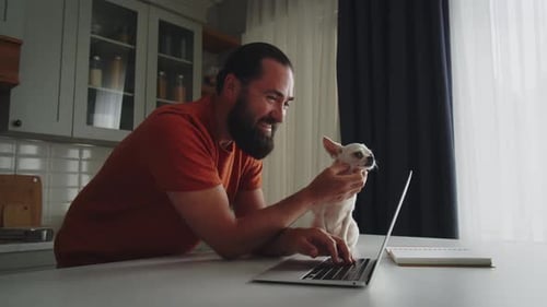 Man Working At Home With His Dog