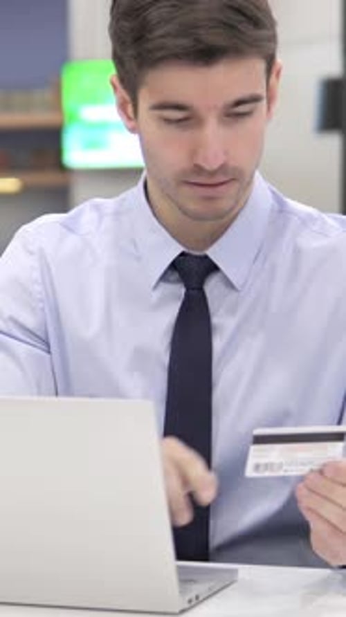 Man Shopping Online with Credit Card and Laptop