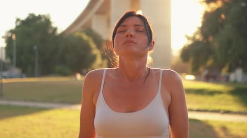 Sporty Woman Doing Meditate Breathing Exercise in Park