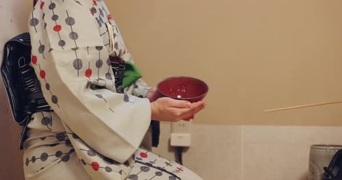 Woman Holding a Bowl in Kimono Indoors