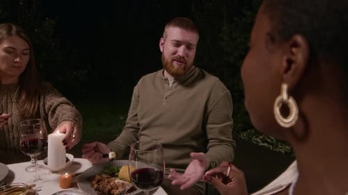 Friends Share a Candlelit Dinner at Night