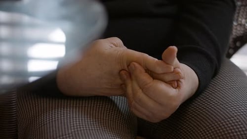 Close Up Of Elderly Female Stroke Survivor Massaging Hemiplegic Right Hand for Relief 24 ps