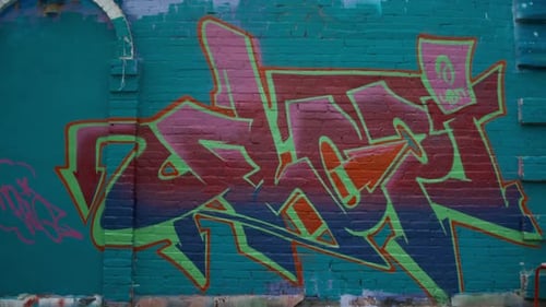 Fertiges Graffiti-Etikett in hellen Farbverläufen an der Backsteinmauer