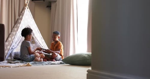 Children Playing Together in a Tent with Tablet